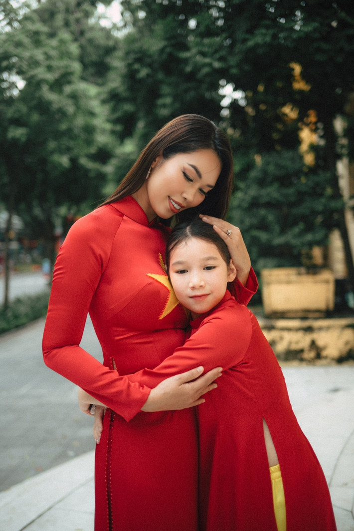 Hà Anh và con gái Myla chọn diện áo dài đỏ nổi bật, in hình ngôi sao vàng trước ngực.
