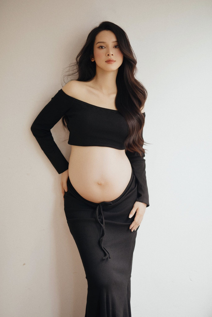Ánh mắt cô tràn ngập tình yêu thương khi vuốt ve chiếc bụng tròn, báo hiệu một sinh linh bé bỏng sắp chào đời. Ảnh: FB Lương Quỳnh