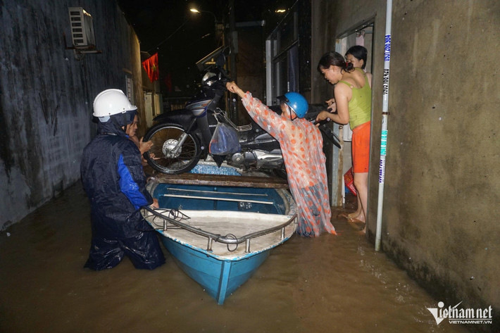 Xe máy được đưa lên thuyền để đưa đến nơi cao hơn.