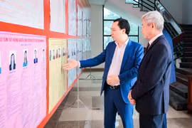 Ông Vũ Văn Tiến, Ủy viên Đoàn Chủ tịch, Trưởng Ban Tuyên giáo Cơ quan Ủy ban Trung ương MTTQ Việt Nam cùng cử tri xem thông tin người ứng cử