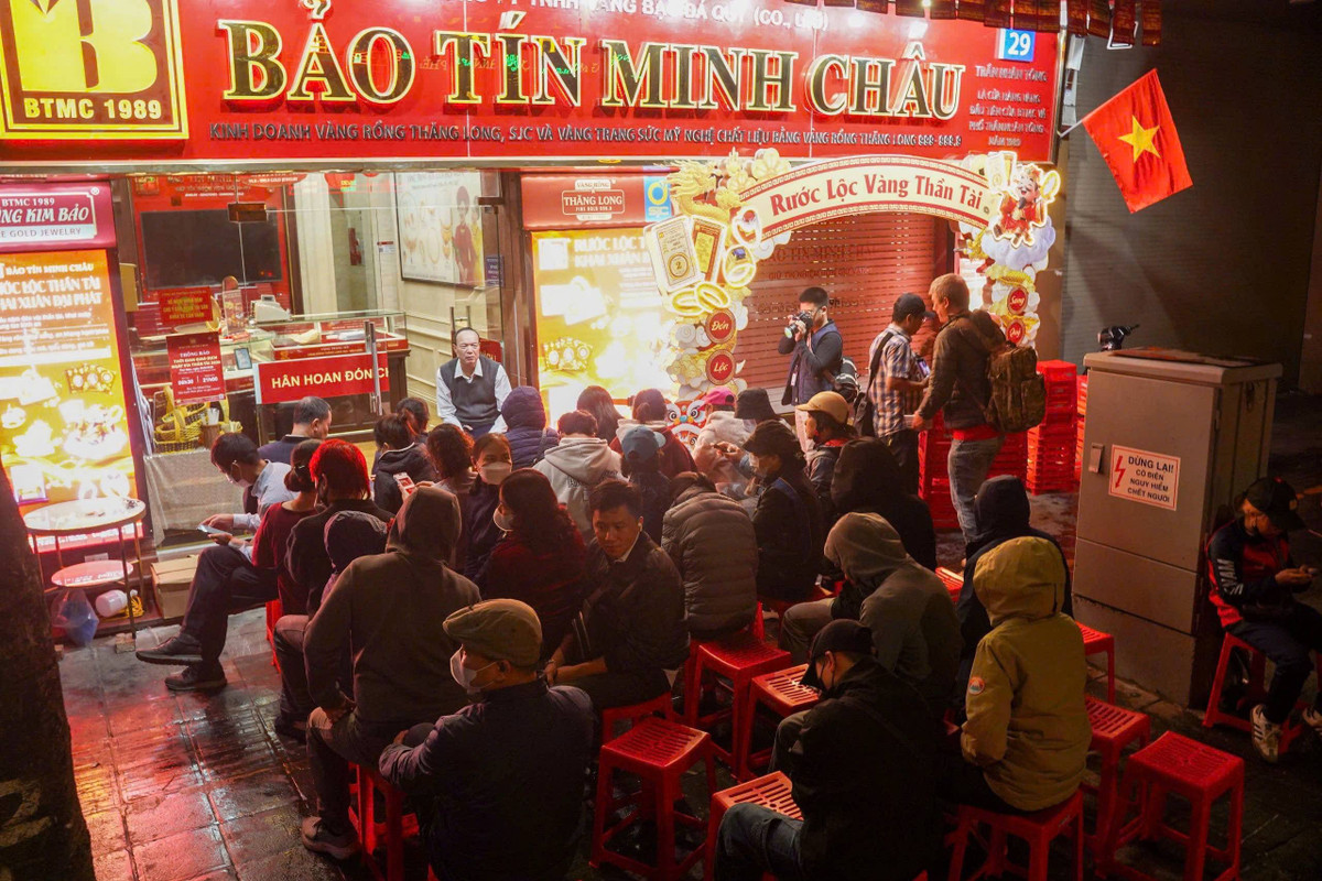 Hình ảnh ghi nhận cảnh người dân kiên nhẫn ngồi đợi tại cửa hàng Bảo Tín Minh Châu trên phố Trần Nhân Tông. Ảnh Gia Đạt