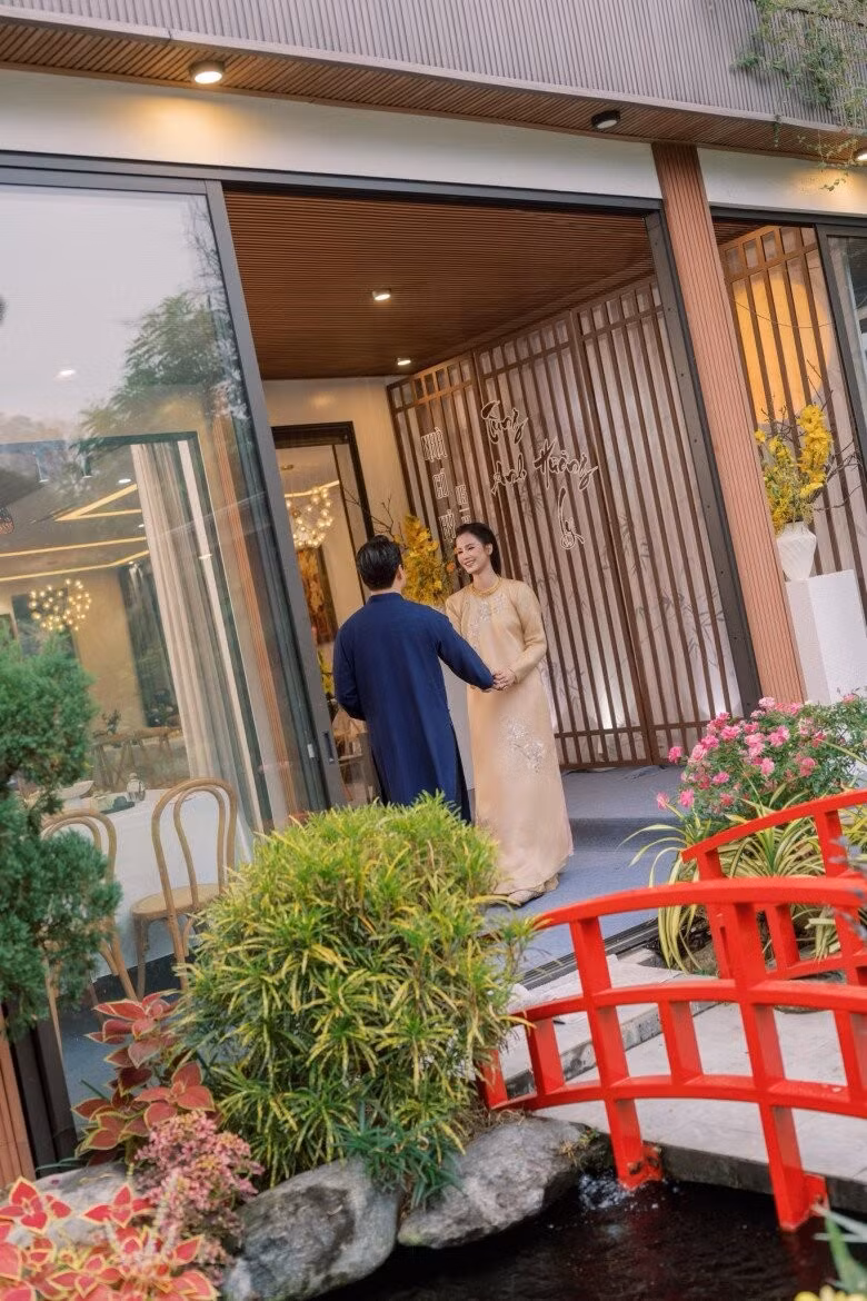 Chiếc cầu gỗ nhỏ sơn đỏ bắc qua mặt hồ, kết nối khu vườn với khu nhà chính. Ảnh: FBNV