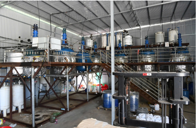 Cuối tháng 1/2025, nhà xưởng xây lắp xong, các đối tượng trong đường dây chuyển nguyên vật liệu, hóa chất và bắt tay vào sản xuất giai đoạn một. Các loại hóa chất được cho vào máy trộn, kết hợp các phụ gia và điều chỉnh nhiệt độ để tạo phản ứng giữa các chất hóa học tạo ra 1,8 tấn bột màu vàng, được đóng vào thùng xốp và gửi vào kho đông lạnh dưới vỏ bọc là chất tạo bọt xử lý nước thải.