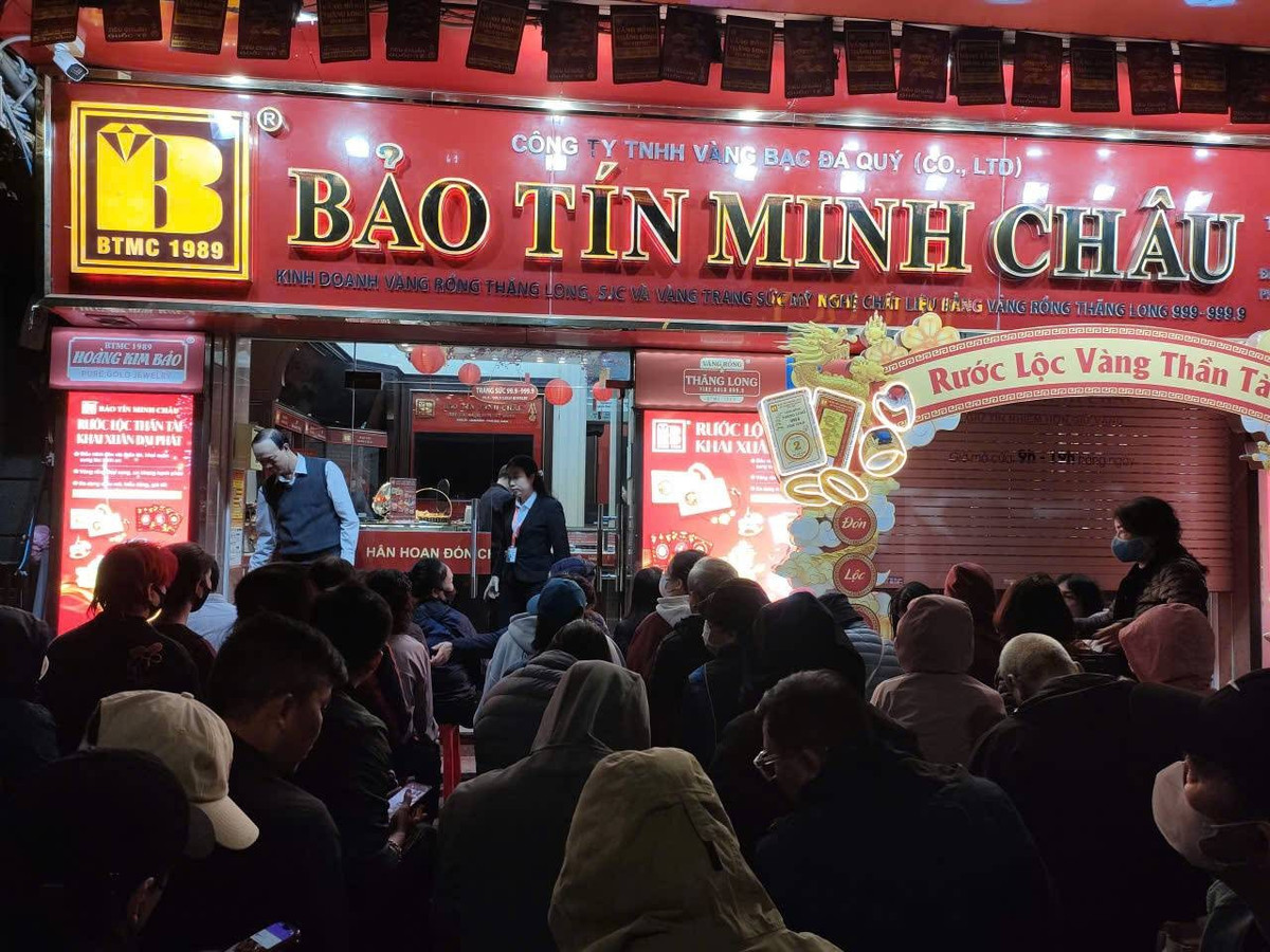 Người dân ngồi xếp hàng chờ đến lượt mua vàng trên phố Trần Nhân Tông, Hà Nội. Ảnh Gia Đạt.