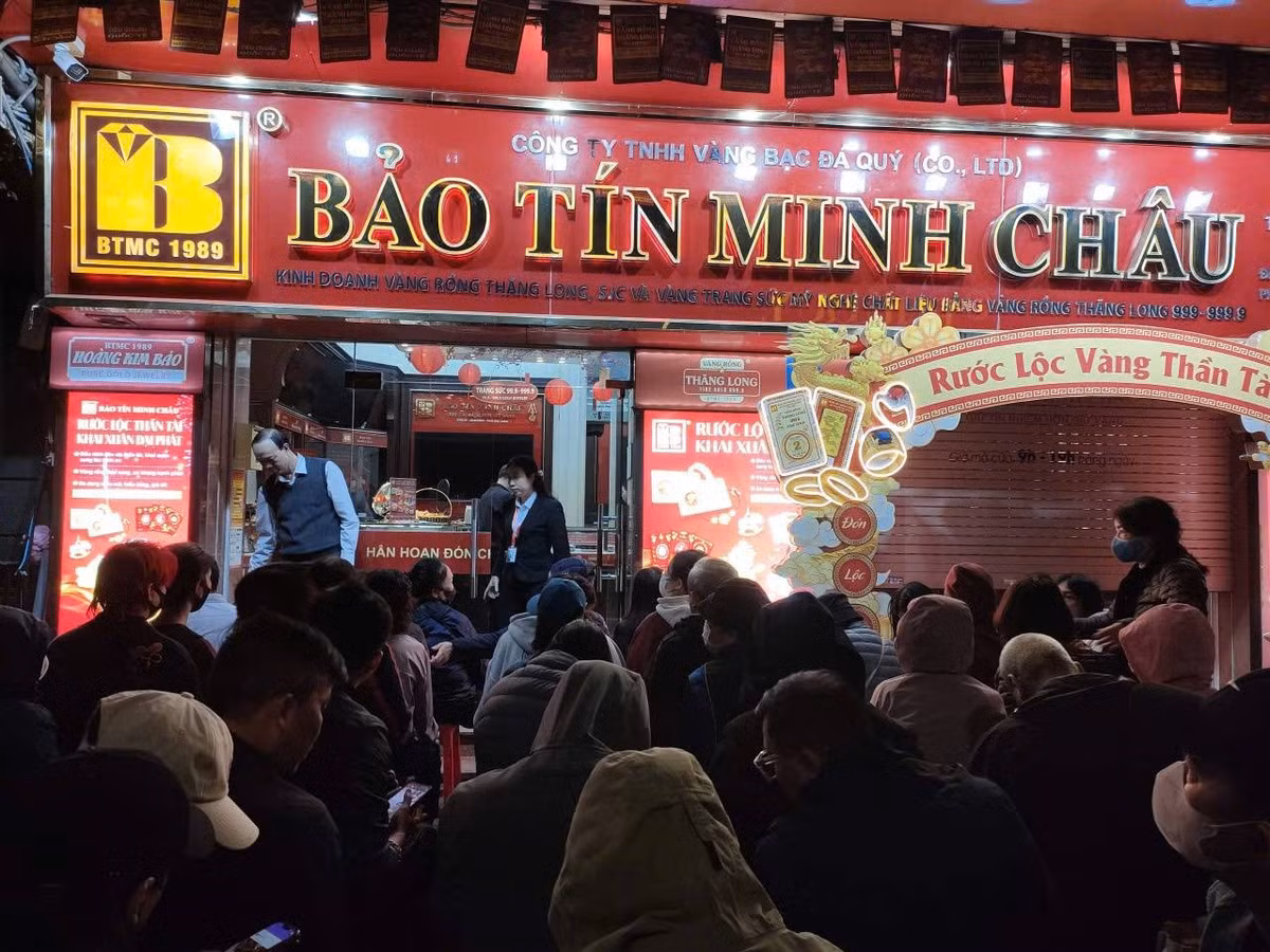 Người dân ngồi xếp hàng chờ đến lượt mua vàng trên phố Trần Nhân Tông, Hà Nội. Ảnh Gia Đạt.