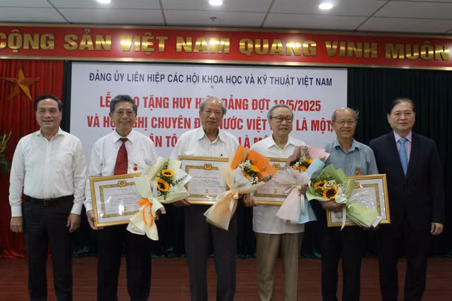 Chủ tịch và Phó Chủ tịch Liên hiệp Hội Việt Nam trao huy hiệu cho các đảng viên.