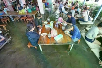 Trước đây, ngập lụt khiến bà lo ngại mất khách, nhưng một bài đăng về cảnh cá bơi dưới chân khách đã lan truyền mạnh, biến nơi này thành điểm check-in độc đáo.