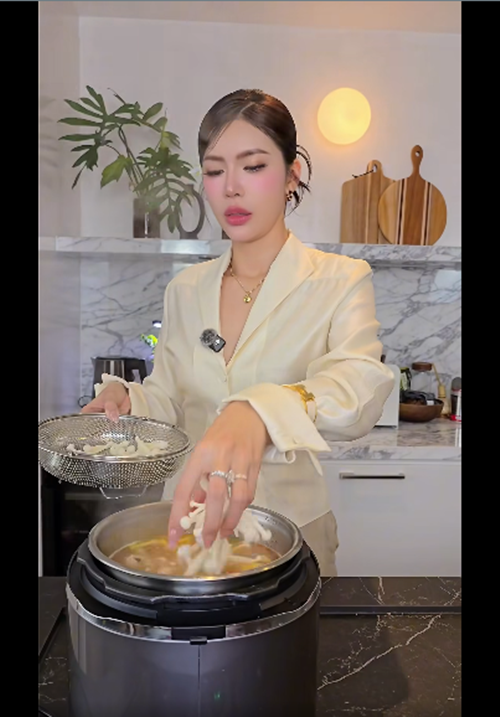 Nữ người mẫu chăm vào bếp nấu nướng. Ảnh: FB Minh Tú.