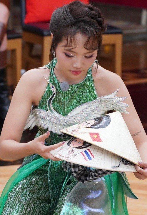 Ca sĩ Phương Mỹ Chi tặng nón lá cho thí sinh ở Sing!Asia 2025. Cô cho biết: “Một chút tâm ý nhỏ dành tặng cho các bạn quốc tế là chiếc nón lá Việt Nam, được vẽ tay trực tiếp mọi người ạ. Trên đó là hình ảnh của Chi, một bên là quốc kỳ Việt Nam, một bên là quốc kỳ nước bạn. Hy vọng mỗi chiếc nón nhỏ này sẽ là một kỷ niệm đẹp về Việt Nam trong lòng bạn bè quốc tế”. Ảnh: FB Phương Mỹ Chi.