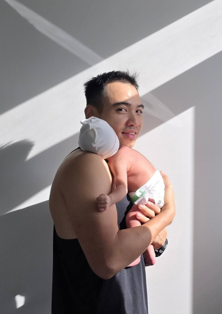 Tuấn Khôi bế ái nữ tắm nắng vào sáng sớm. Ảnh: FB Tuấn Khôi.