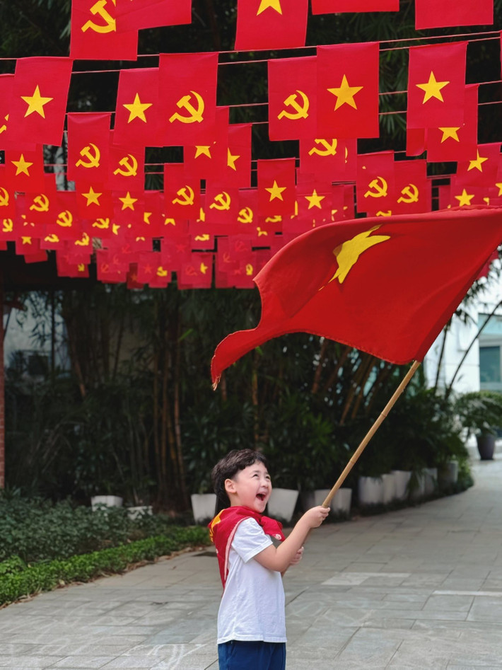 Con trai Tú Anh hào hứng vẫy cờ đỏ sao vàng. Ảnh: FB Tú Anh.