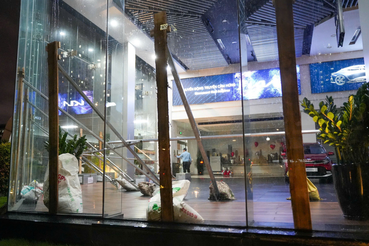 Lúc 18h40, nhân viên một showroom ở khu đô thị Thành phố Giao lưu (phường Phú Diễn) khẩn trương gia cố văn phòng để chống bão. Các thanh gỗ lớn được dựng lên trước cửa kính và chặn lại bằng nhiều thanh thép, bao tải cát. Ôtô được di chuyển vào trong, cách xa cửa để đảm bảo an toàn.