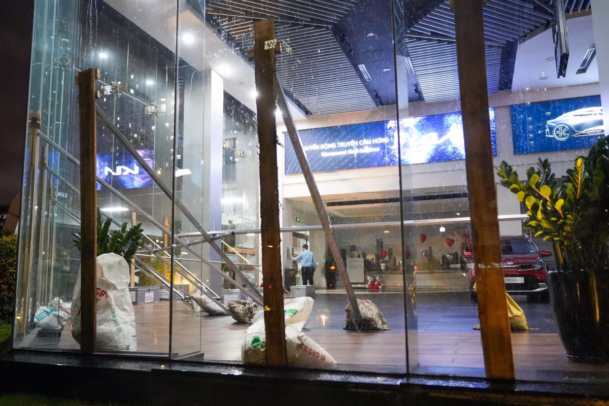 Lúc 18h40, nhân viên một showroom ở khu đô thị Thành phố Giao lưu (phường Phú Diễn) khẩn trương gia cố văn phòng để chống bão. Các thanh gỗ lớn được dựng lên trước cửa kính và chặn lại bằng nhiều thanh thép, bao tải cát. Ôtô được di chuyển vào trong, cách xa cửa để đảm bảo an toàn.