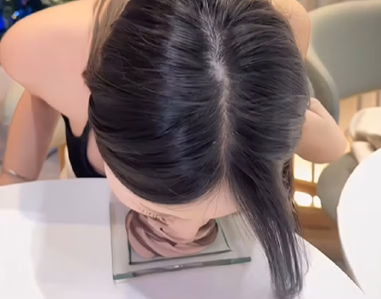 Thay vì cầm kem trên tay, washi_iiii cúi sát người xuống bàn và “ngoạm” trọn cây kem theo chiều thẳng đứng.