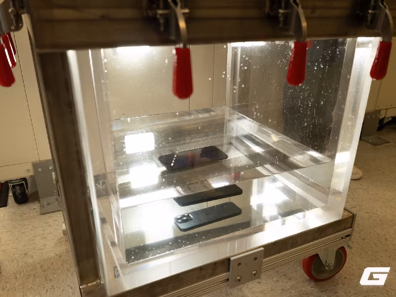 Ở thử nghiệm thả rơi, Apple sử dụng robot để tái hiện hàng loạt tình huống thực tế với các góc rơi và bề mặt khác nhau như đá granit, nhựa đường hay gỗ ép.(Ảnh: Genk)