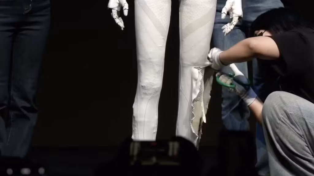 CEO XPeng, ông He Xiaopeng, đã mở khóa trang phục và cắt lớp bọc để lộ cấu trúc cơ khí bên trong.