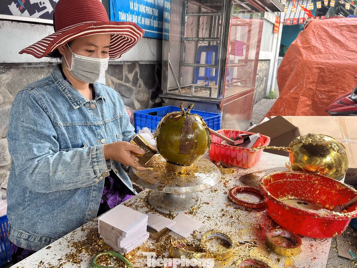 Năm nay, dừa dát vàng cũng là một trong những mặt hàng độc lạ, mang ý nghĩa phong thủy được nhiều gia đình lựa chọn để bày mâm ngũ quả hoặc làm quà tặng. Từ những trái dừa bình thường, qua nhiều công đoạn thủ công, người thợ phủ lên lớp vàng công nghiệp 24K, kết hợp trang trí chữ, hoa văn… tạo nên thành phẩm có giá cao gấp 2 - 3 lần.
