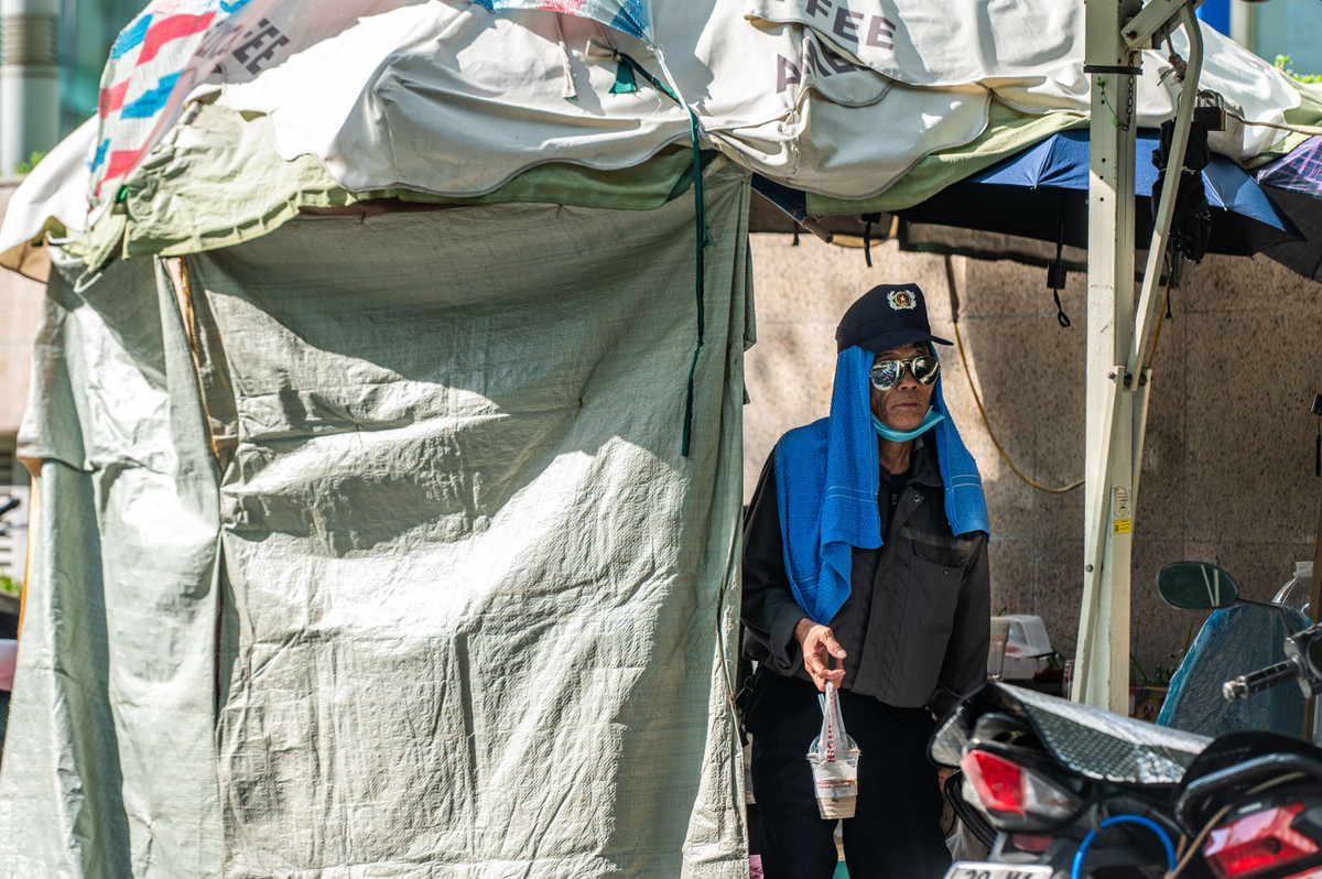 Ông Vũ Văn Thống (63 tuổi, phường Thanh Xuân) sử dụng những tấm bạt để che nắng cho bốt bảo vệ của mình trên đường Nguyễn Chánh.