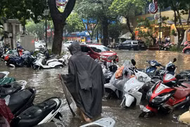 Xe để trên vỉa hè phố Trần Hưng Đạo cũng bị ngập quá nửa bánh. Ảnh: Thanh Thúy.