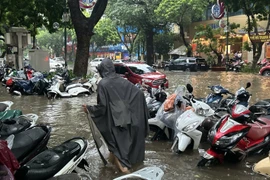 Xe để trên vỉa hè phố Trần Hưng Đạo cũng bị ngập quá nửa bánh. Ảnh: Thanh Thúy.