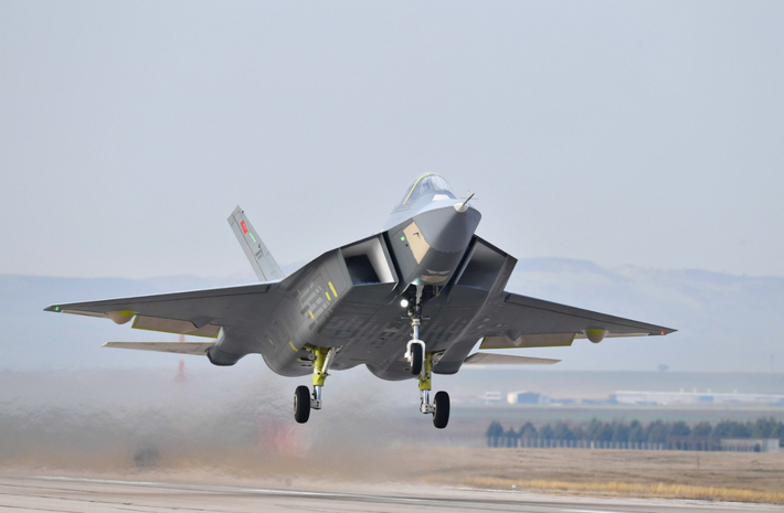 Theo Turkish Aerospace Industries, máy bay phản lực này thực hiện chuyến bay đầu tiên vào ngày 21/2/2024, đạt độ cao 2.438 mét trong cuộc thử nghiệm kéo dài 13 phút. Chuyến bay thứ hai diễn ra vào ngày 6/5/2024, leo lên độ cao 3.048 mét và thử nghiệm tăng lực hai động cơ được tiến hành vào ngày 6/12/2024. Máy bay có thiết kế góc cạnh để giảm thiểu khả năng phát hiện của radar, tốc độ tối đa dự kiến là Mach 1,8 (tương đương với khoảng 2.225 km/h) và bán kính chiến đấu khoảng hơn 1.100 km. Ảnh: @ Daily Sabah.