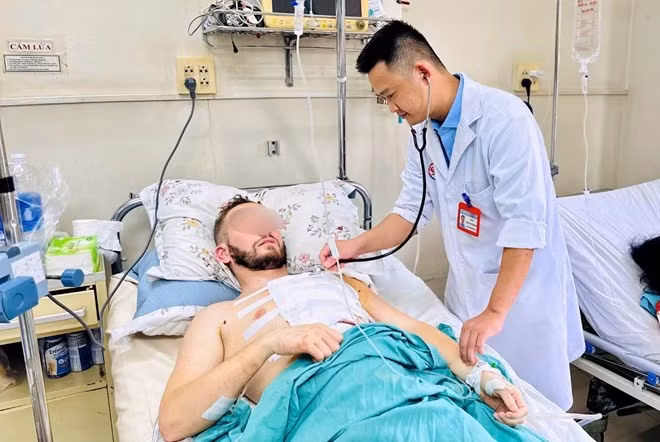 Bác sĩ thăm khám cho nam bệnh nhân sau phẫu thuật.