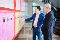 Ông Vũ Văn Tiến, Ủy viên Đoàn Chủ tịch, Trưởng Ban Tuyên giáo Cơ quan Ủy ban Trung ương MTTQ Việt Nam cùng cử tri xem thông tin người ứng cử