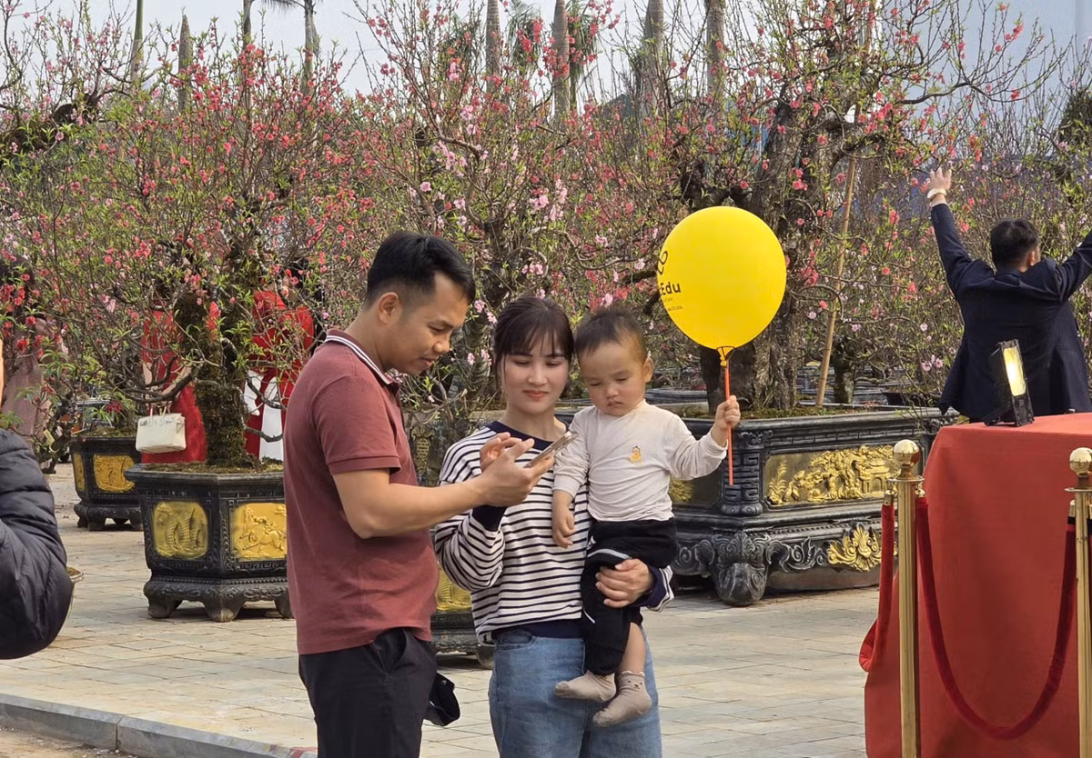 Cũng không ít gia đình đưa con nhỏ đi chơi chợ Tết, vừa tham quan vừa lưu giữ những bức ảnh kỷ niệm trong không gian ngập tràn sắc xuân.