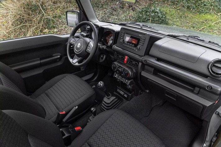 Không gian bên trong Jimny bản đặc biệt vẫn giữ phong cách đơn giản vốn có của dòng xe off-road này. Xe được trang bị thảm sàn cao su cho cả khoang hành khách và khoang chứa đồ, lựa chọn phù hợp với nhu cầu đi đường xấu. Ở bảng điều khiển trung tâm, Suzuki gắn thêm một tấm biển kỷ niệm riêng để nhấn mạnh tính chất giới hạn của phiên bản.
