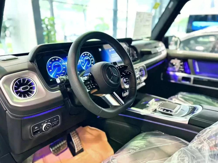 Bên trong khoang lái, G 580 EQ Edition One thể hiện đẳng cấp của một mẫu SUV điện hạng sang thực thụ. Nội thất bọc da Nappa cao cấp, phối hai tông màu xám ngọc trai và đen, điểm xuyết bằng những đường chỉ thêu xanh lam nổi bật.
