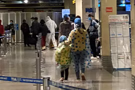 Hành khách mặc áo mưa, bảo hộ kín mít khi đi máy bay tại Tân Sơn Nhất