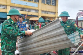 Lực lượng biên phòng hỗ trợ người dân thị trấn Cửa Việt khắc phục hậu quả sau bão số 4