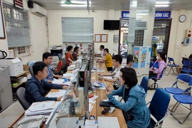 Giải quyết thủ tục cho người dân tại Bảo hiểm Xã hội quận Thanh Xuân - Ảnh: Báo Hà Nội Mới 