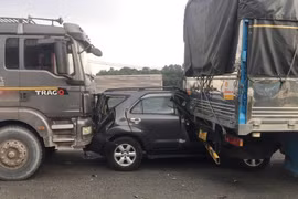 Chiếc ôtô 7 chỗ bị kẹp giữa 2 xe tải, hư hỏng nặng.