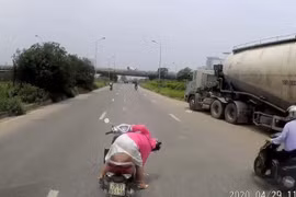 Người phụ nữ quay xe máy giữa đại lộ nhặt đồ bất chấp nguy hiểm