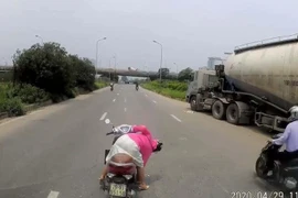 Người phụ nữ quay xe máy giữa đại lộ nhặt đồ bất chấp nguy hiểm
