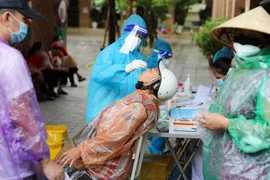 Lấy mẫu xét nghiệm cho người dân tại Hà Nội. (Ảnh: Thanh Tùng/TTXVN)