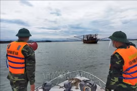 Cán bộ chiến sỹ Biên phòng Quảng Bình kêu gọi, hướng dẫn tàu, thuyền vào neo đậu tại bến thuyền, cảng cá đảm bảo an toàn. Ảnh minh họa: TTXVN phát