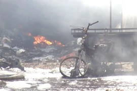 Bên trong bãi xe cháy có nhiều phương tiện gồm xe máy, xe ba gác máy, xe tải bị cháy, hư hỏng