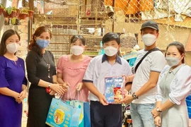 Đại diện Văn phòng Đại diện Báo Tri thức và Cuộc sống tại TPHCM và ông Trương Văn Toàn tặng quà và trao học bổng cho trẻ mồ côi do covid-19 tại phường 3, quận 11, TPHCM.