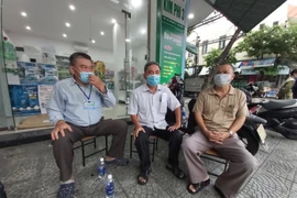 Tổ trưởng Tổ dân phố 35 và Bí thư Chi bộ khu dân cư Hoà Phú 5 cùng người dân trao đổi việc hỗ trợ quà. 