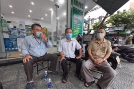 Tổ trưởng Tổ dân phố 35 và Bí thư Chi bộ khu dân cư Hoà Phú 5 cùng người dân trao đổi việc hỗ trợ quà. 