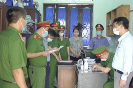 Cơ quan chức năng tống đạt quyết định khởi tố 2 bị can Tạ Xuân Ngọc và Cao Thị Thanh Thuận.