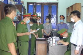 Cơ quan chức năng tống đạt quyết định khởi tố 2 bị can Tạ Xuân Ngọc và Cao Thị Thanh Thuận.