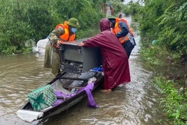 Công an huyện Lệ Thủy hỗ trợ người dân vận chuyển đồ dùng sinh hoạt.