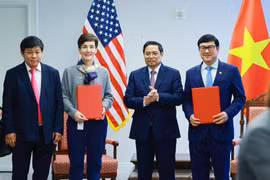 Bà Stephanie von Friedeburg, Phó Chủ tịch điều hành cao cấp IFC (thứ hai từ trái sang) và ông Trần Hoài Nam, Phó Tổng Giám đốc HDBank (bìa phải) trao văn kiện ký kết dưới sự chứng kiến của Thủ tướng Chính phủ Phạm Minh Chính.