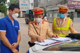 Cán bộ CSGT Đội CSGT đường bộ số 15 hướng dẫn người vi phạm các bước nộp phạt online.