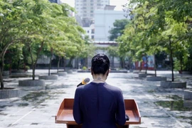 Cô hiệu phó đọc diễn văn khai giảng trước sân trường không bóng người