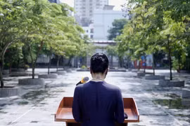 Cô hiệu phó đọc diễn văn khai giảng trước sân trường không bóng người