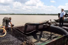 Lực lượng làm nhiệm vụ đo đạc lượng cát khai thác trái phép. Ảnh: Công an tỉnh Tiền Giang.